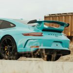 teal sedan beside trailer truck