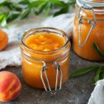 a jar of orange juice next to a jar of oranges