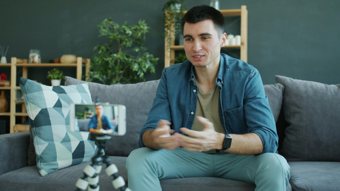 Man talking to a smartphone camera on a tripod